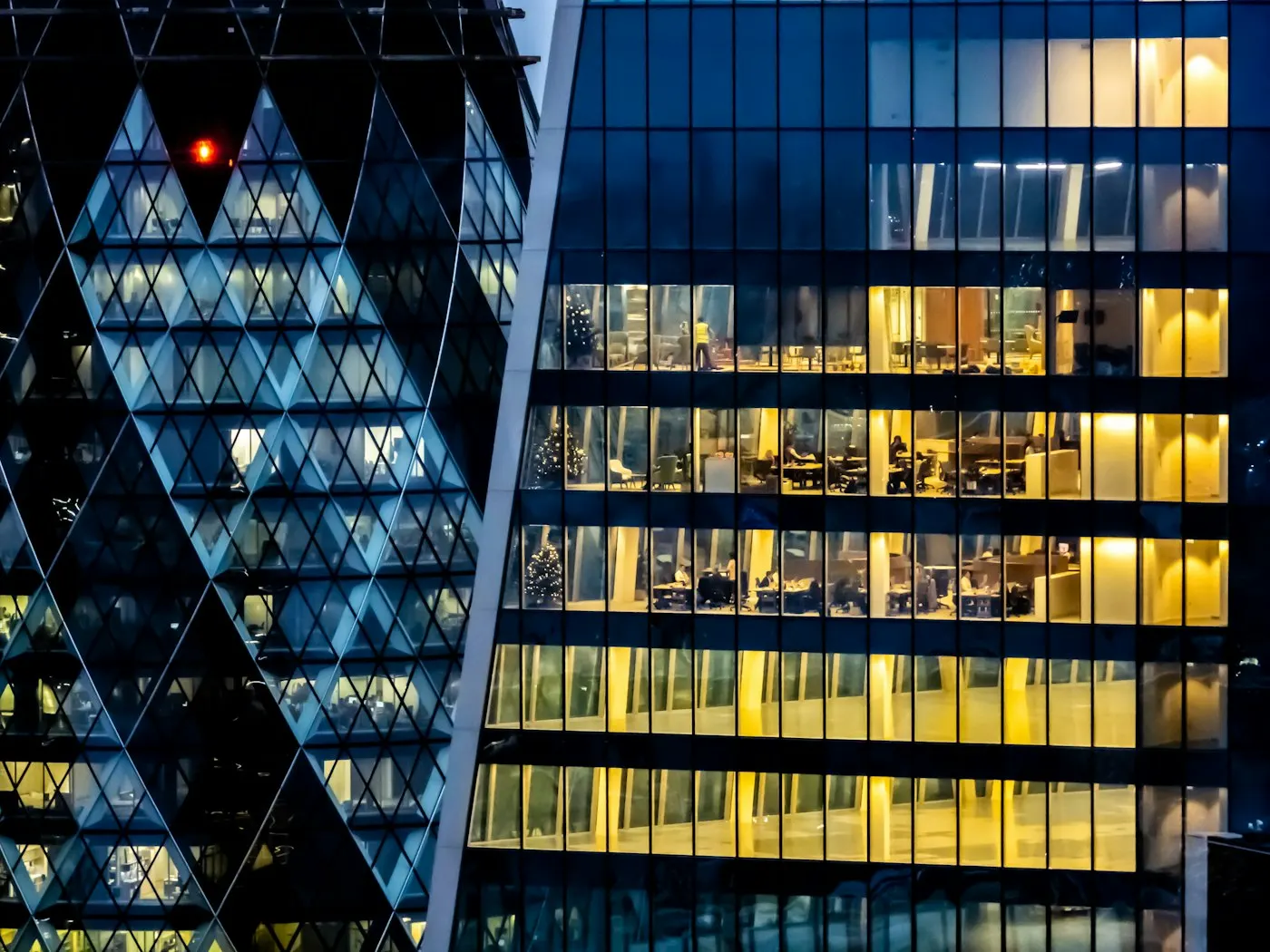 A glass office skyscraper lit up at dusk