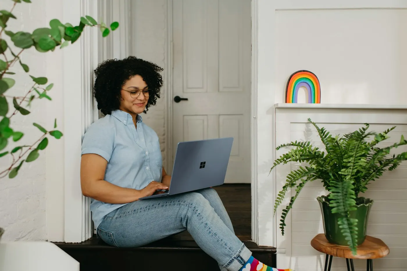 A person typing on a laptop in a home office setting