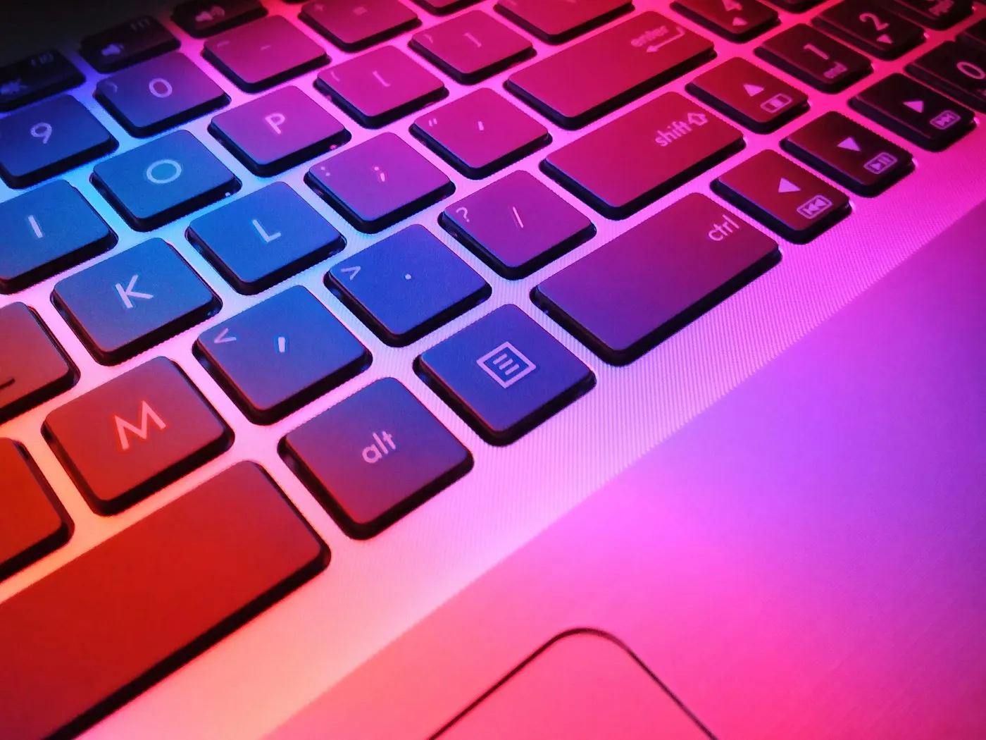 Close-up of hands typing on a laptop keyboard