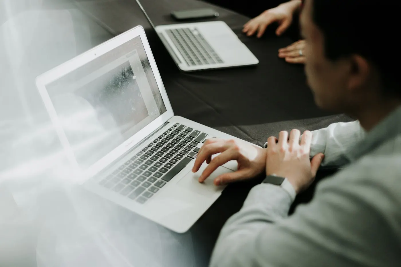 A developer typing on a laptop at a desk