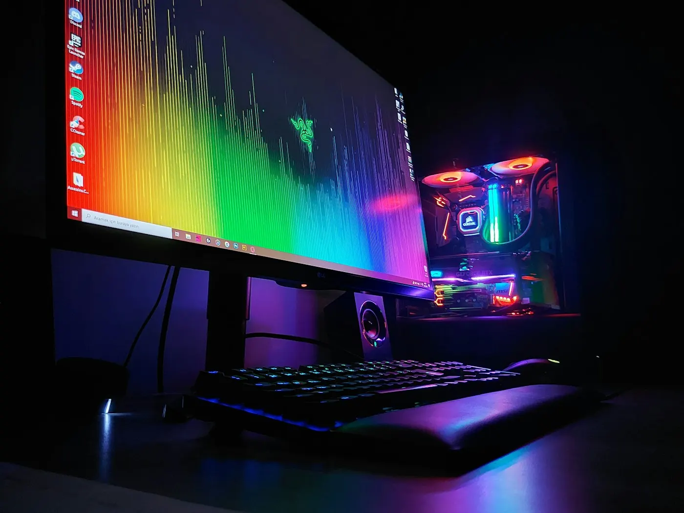 A dimly lit gaming and streaming desk glowing with monitor light