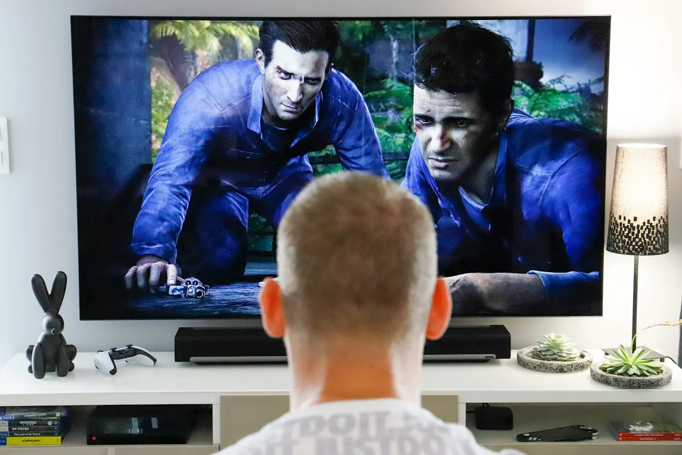 A game controller held in front of a TV in a living room