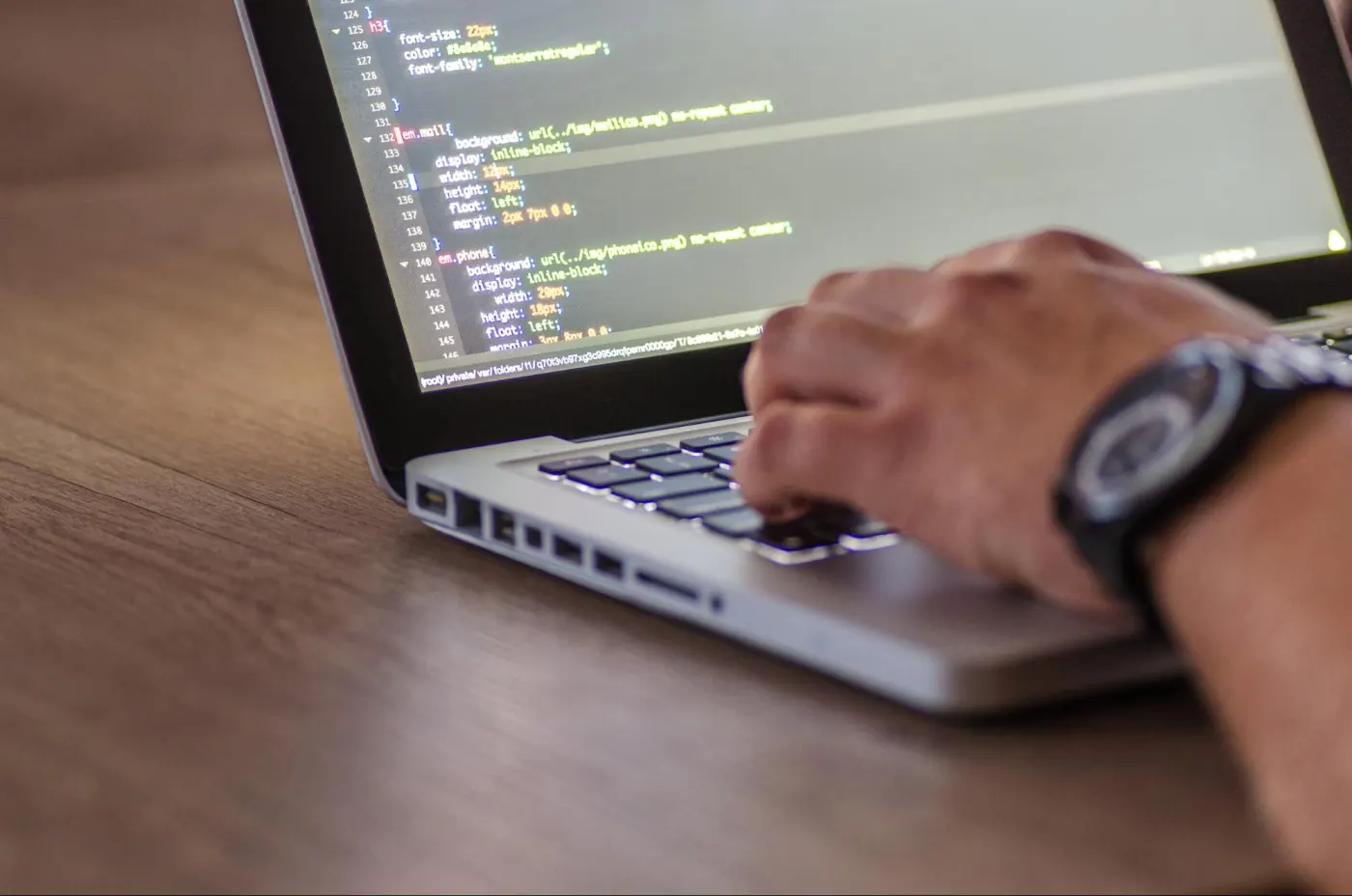 An early-career developer working at a laptop with focus and determination, representing the harder but still viable path into software engineering in 2026 for those who pursue depth over generic skills