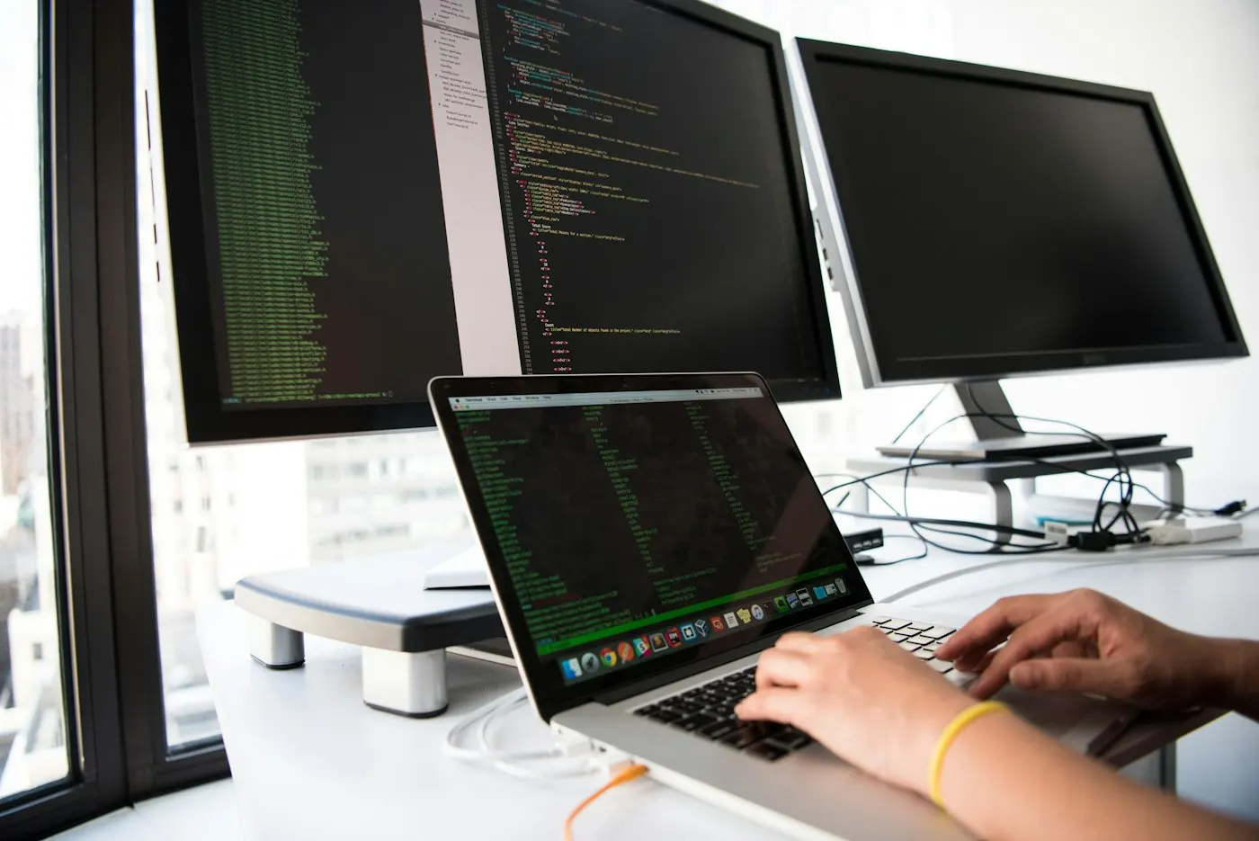A developer workstation with two monitors showing code