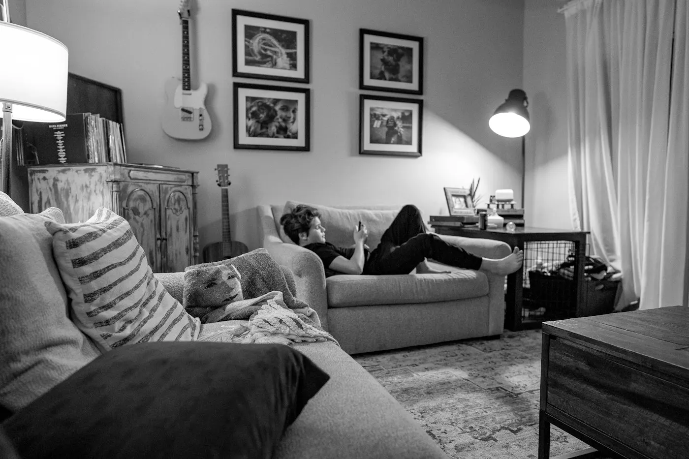 A teenager sitting on a couch looking at a phone screen