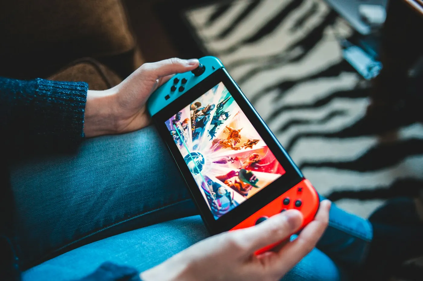 Person holding a handheld gaming device with both hands