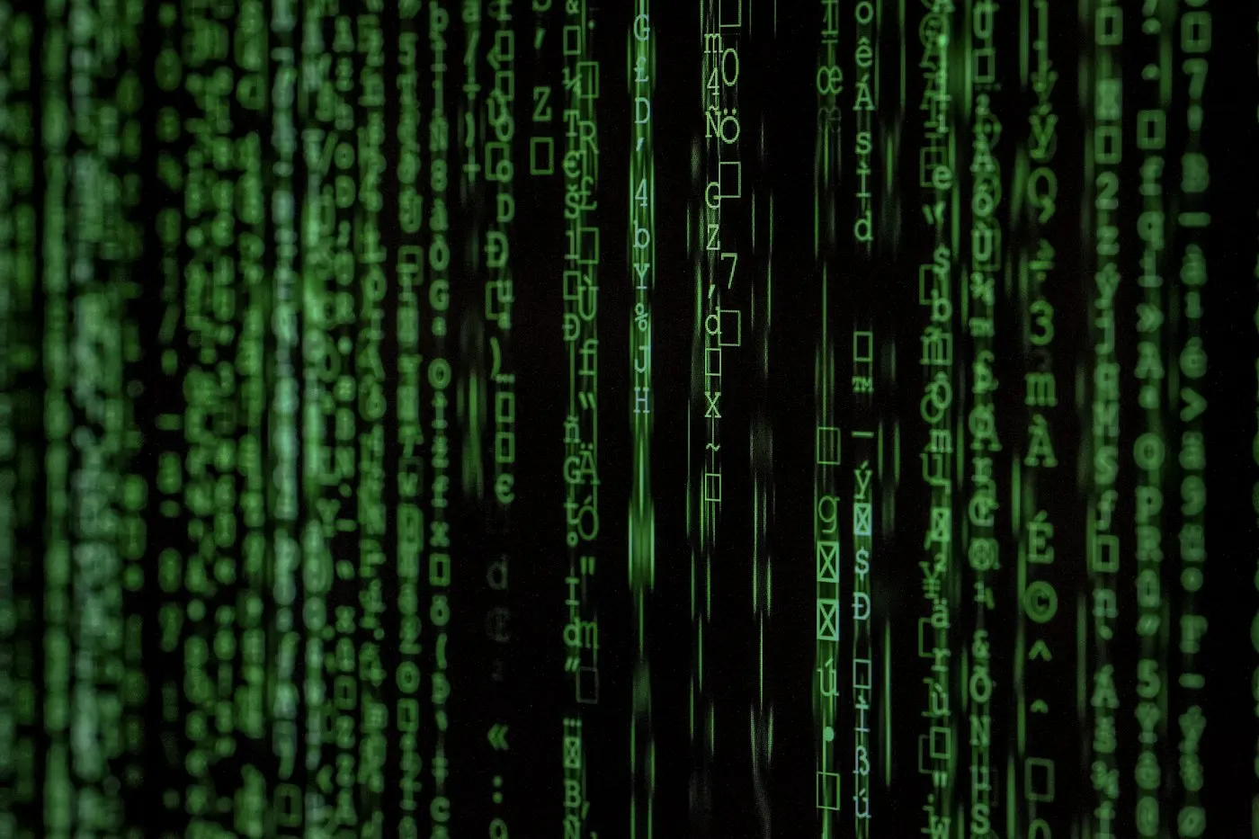 Glowing lines of code on a computer screen in a dark room