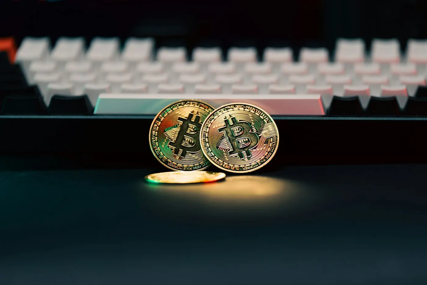 Stack of coins resting beside a computer keyboard