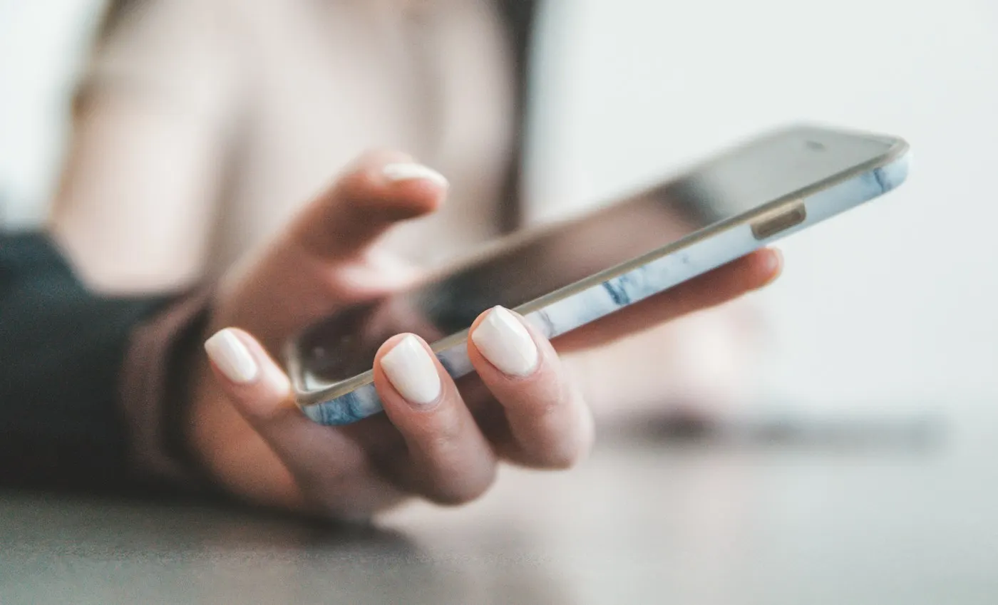 Person holding a smartphone showing a chat interface