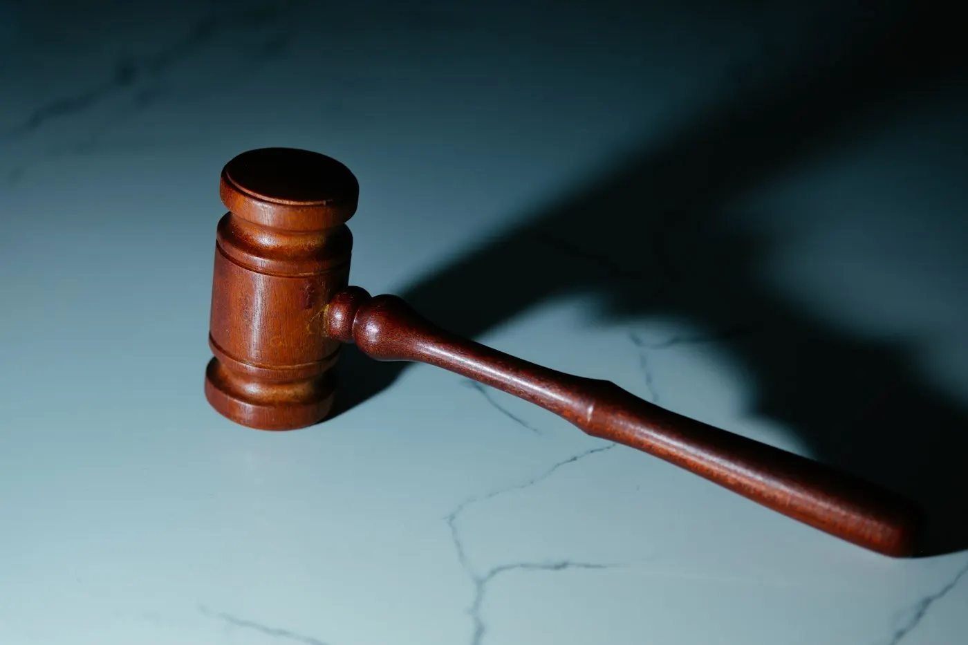 A gavel resting on a wooden desk in a courtroom