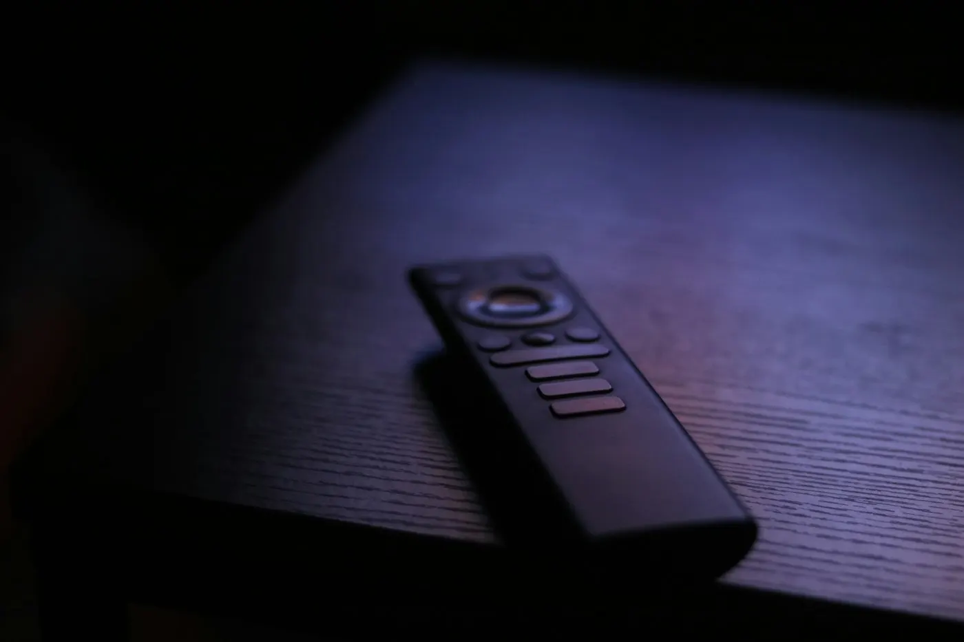 A hand holding a streaming remote control