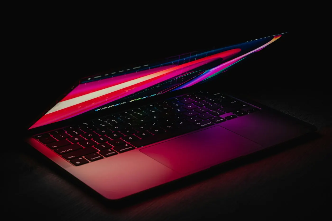 Lines of code glowing on a laptop screen in a dim room