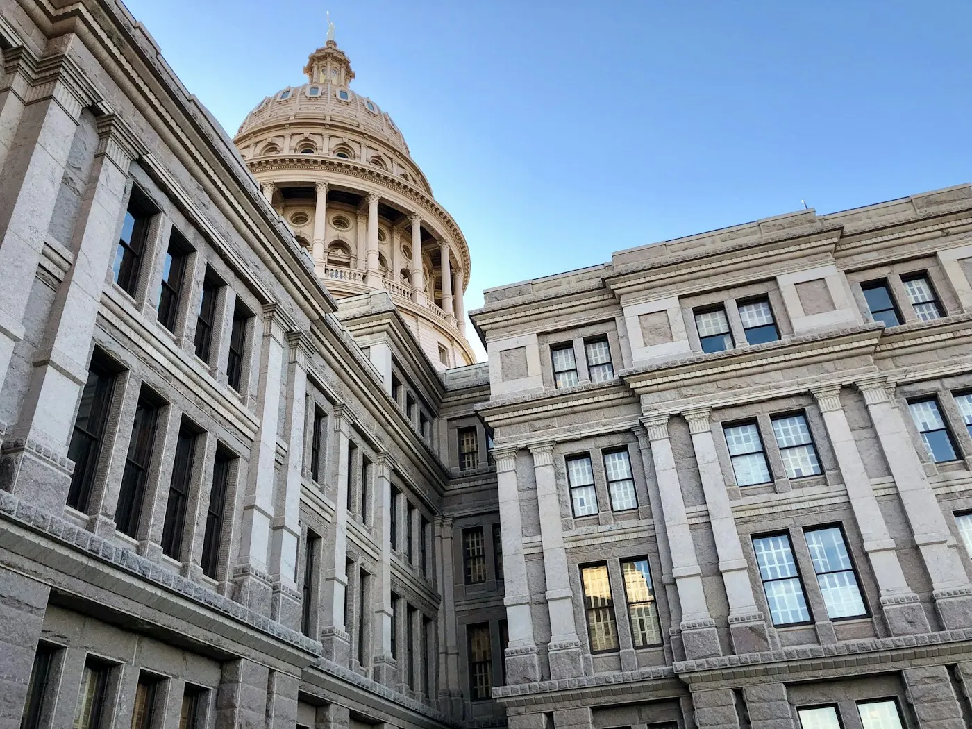 Exterior of a state capitol building under a blue sky