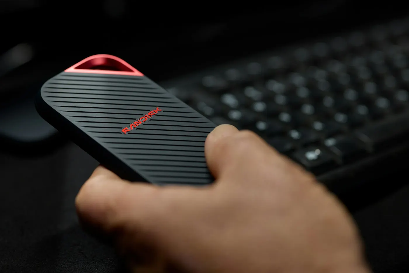 A person holding a small portable storage drive