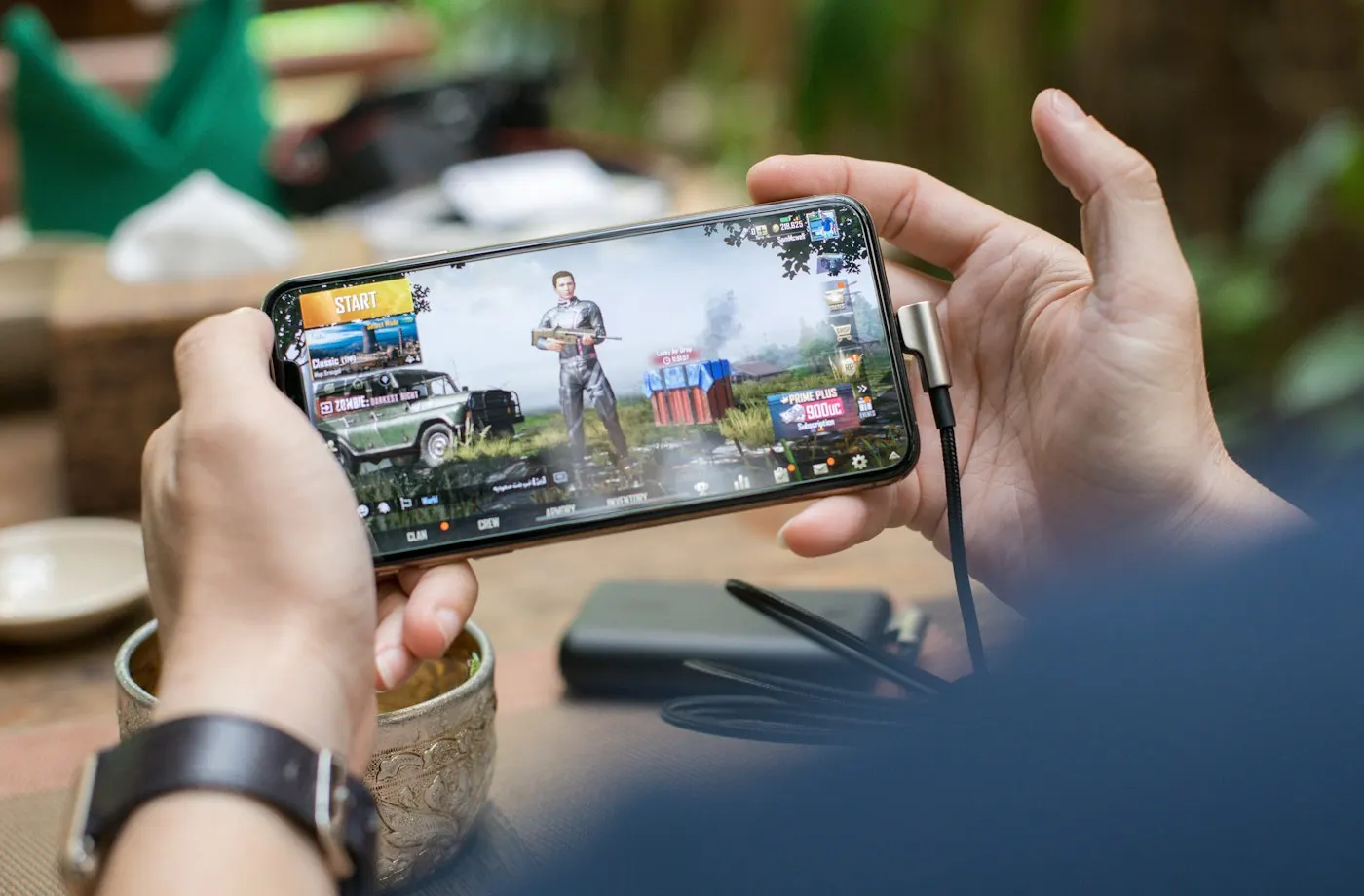 Person holding a smartphone showing a mobile game