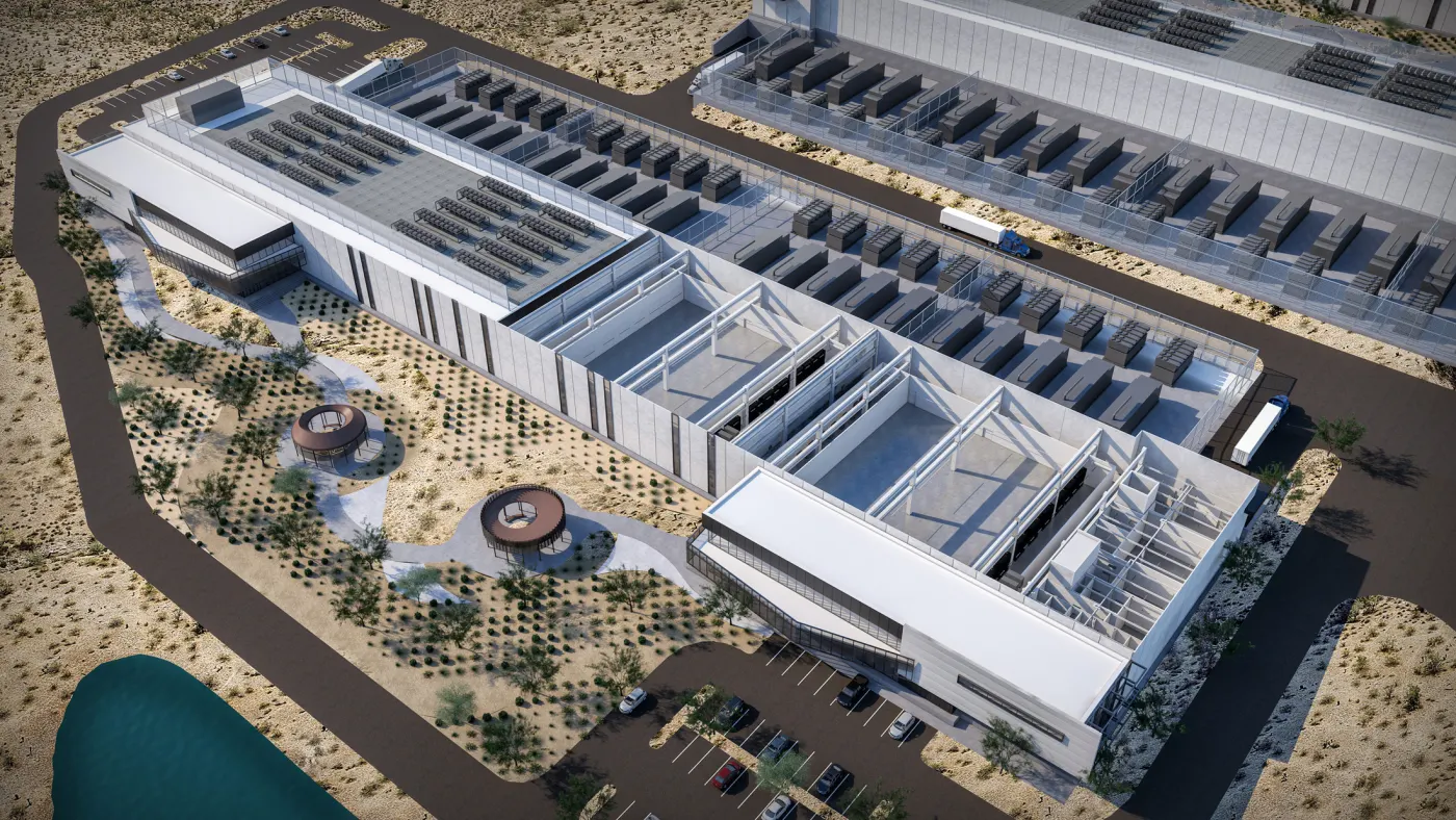 Aerial view of a large AI data center campus showing rows of warehouse-style buildings, cooling towers and electrical substations that illustrate its industrial scale