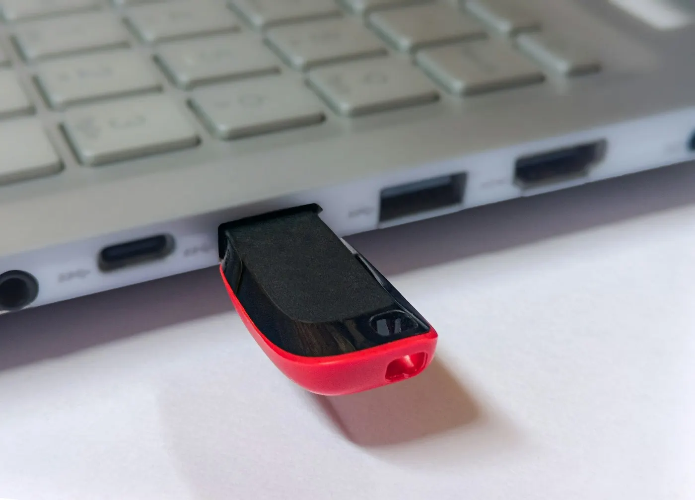 A USB flash drive plugged into the side of a laptop