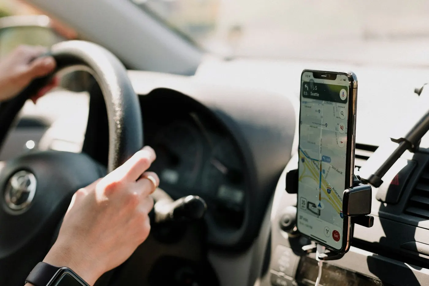 Person holding a smartphone showing a navigation map