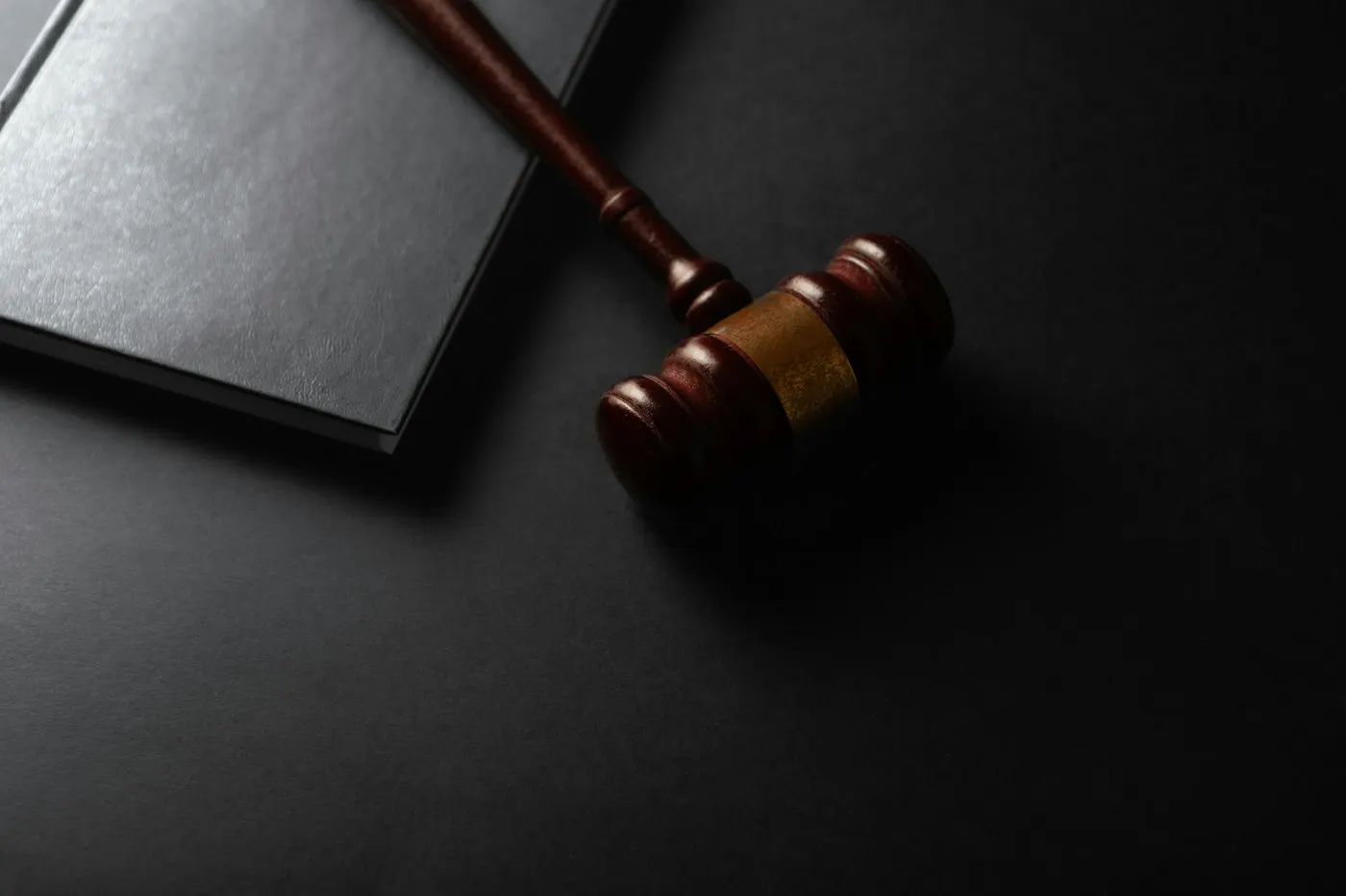 A gavel resting on a wooden courtroom desk