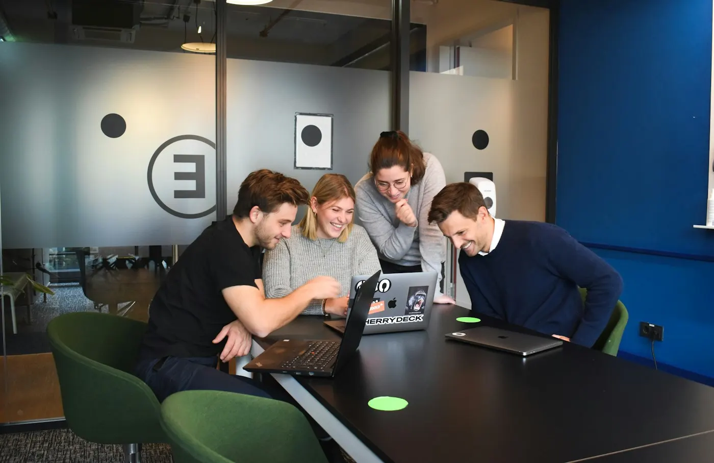 Developers collaborating around laptop screens