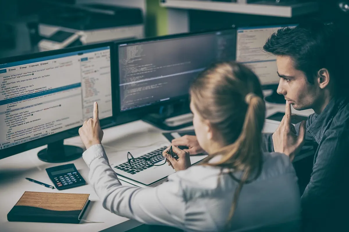 A developer calmly reviewing code on a large monitor in a modern workspace, representing the shift from raw coding speed to judgment and evaluation as the defining skill of effective developers in 2026
