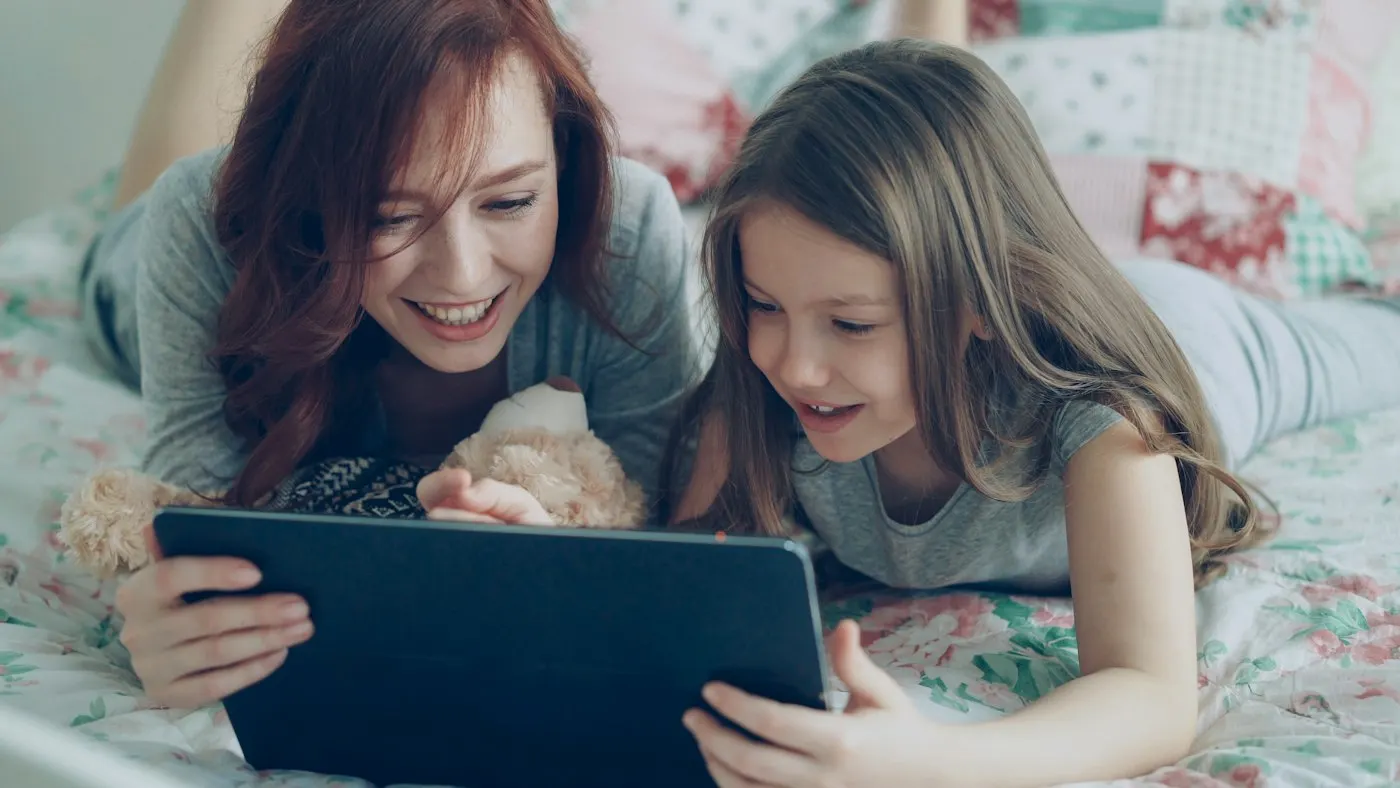 A parent and child looking at a tablet together