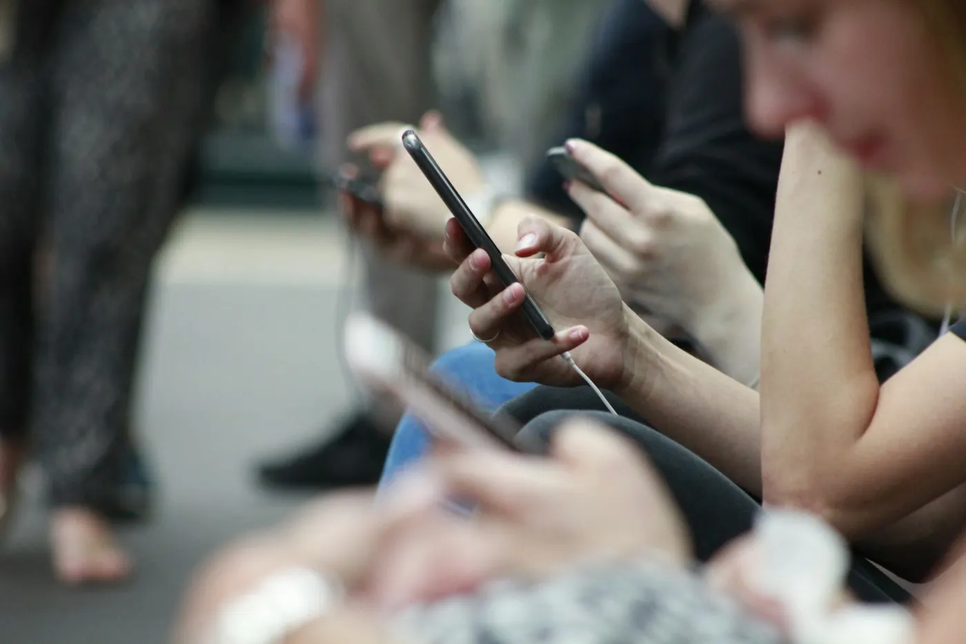 A group of friends looking at their phones while texting