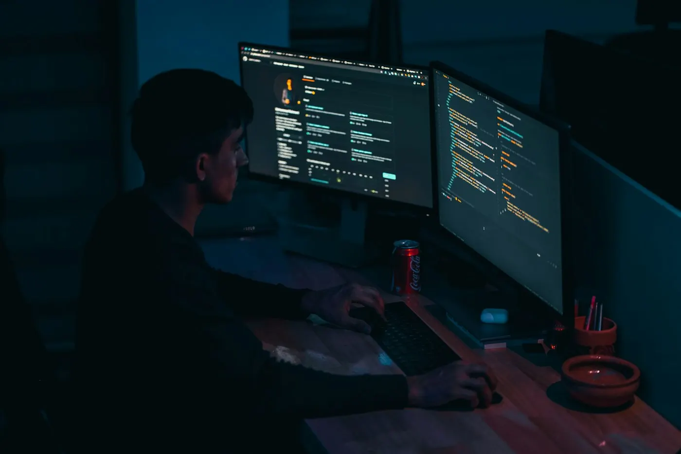 Developer typing code across two monitors