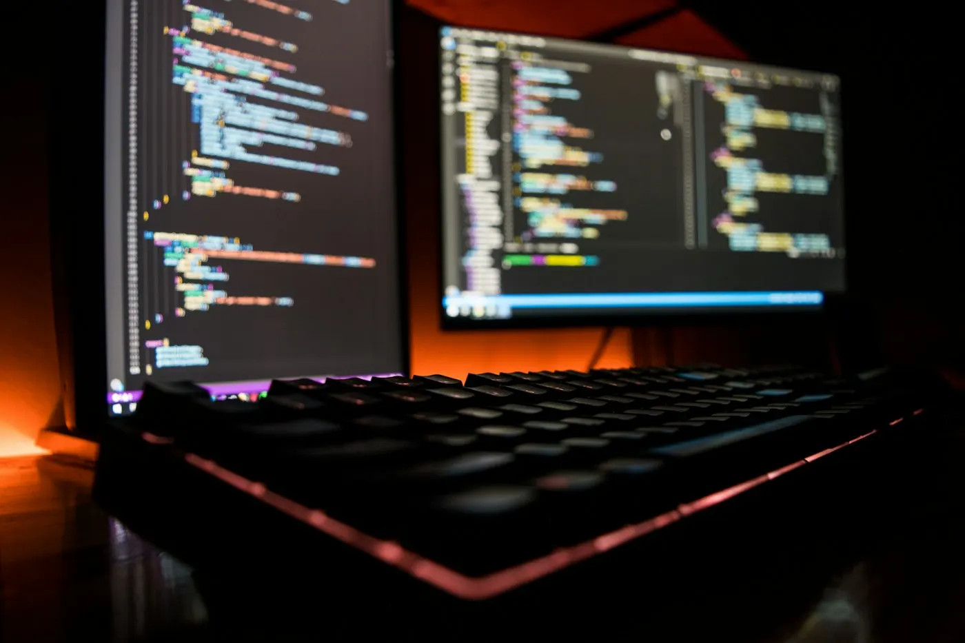 A developer working across two monitors filled with code