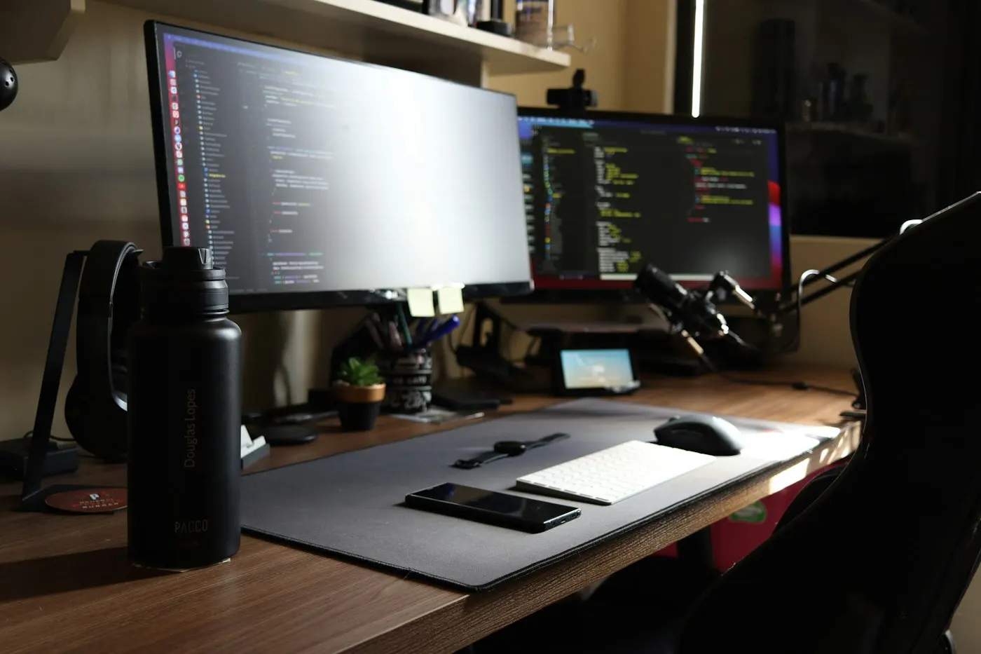 An office desk with dual computer monitors showing data