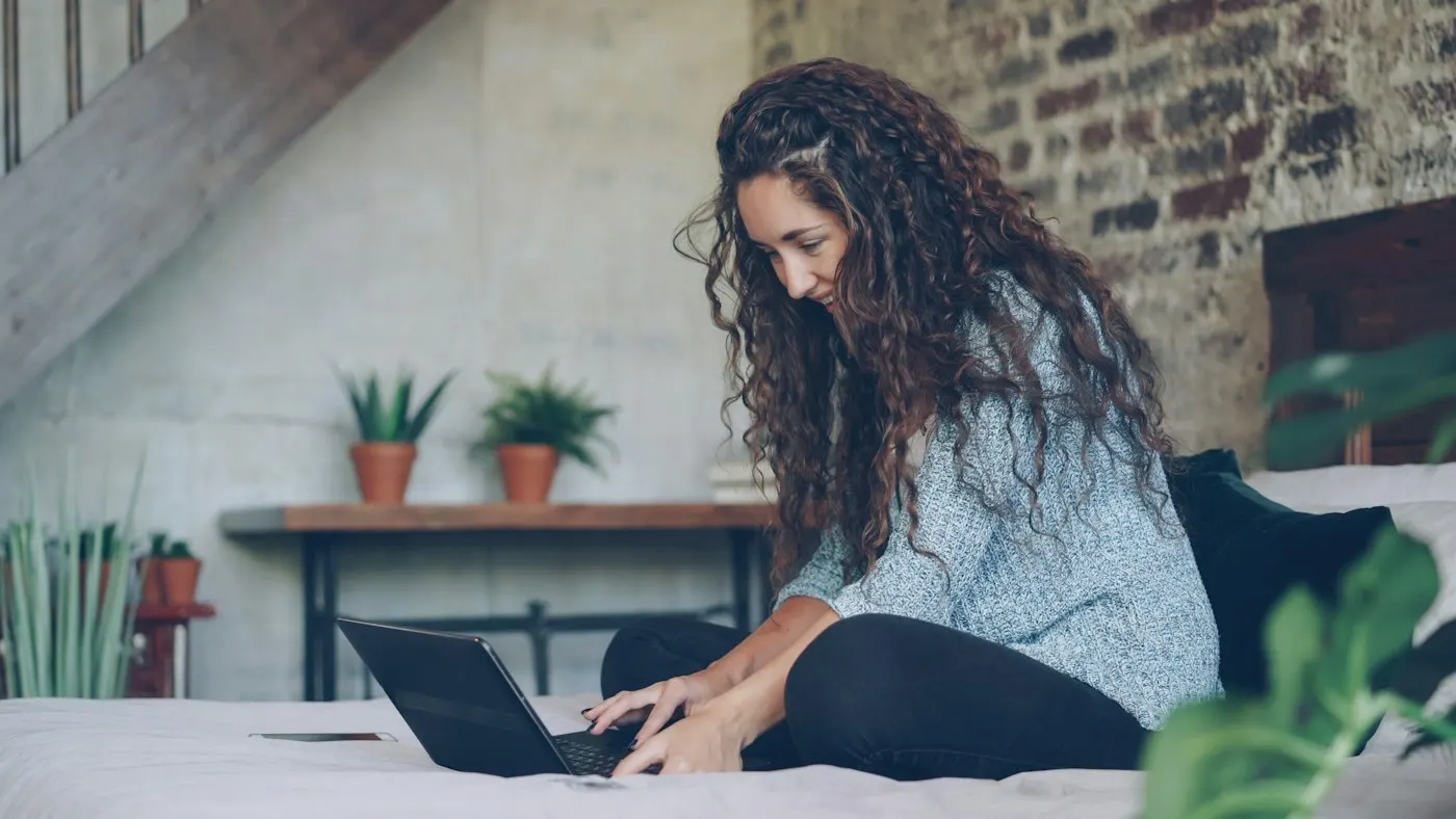 Hands typing a credit card number near a laptop