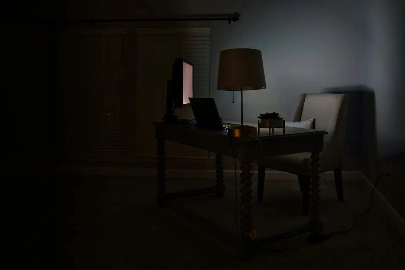 A dimly lit home gaming setup with a controller and glowing screen