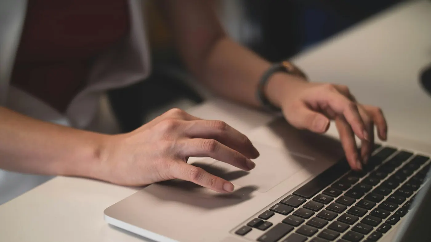 Person typing a password on a laptop keyboard